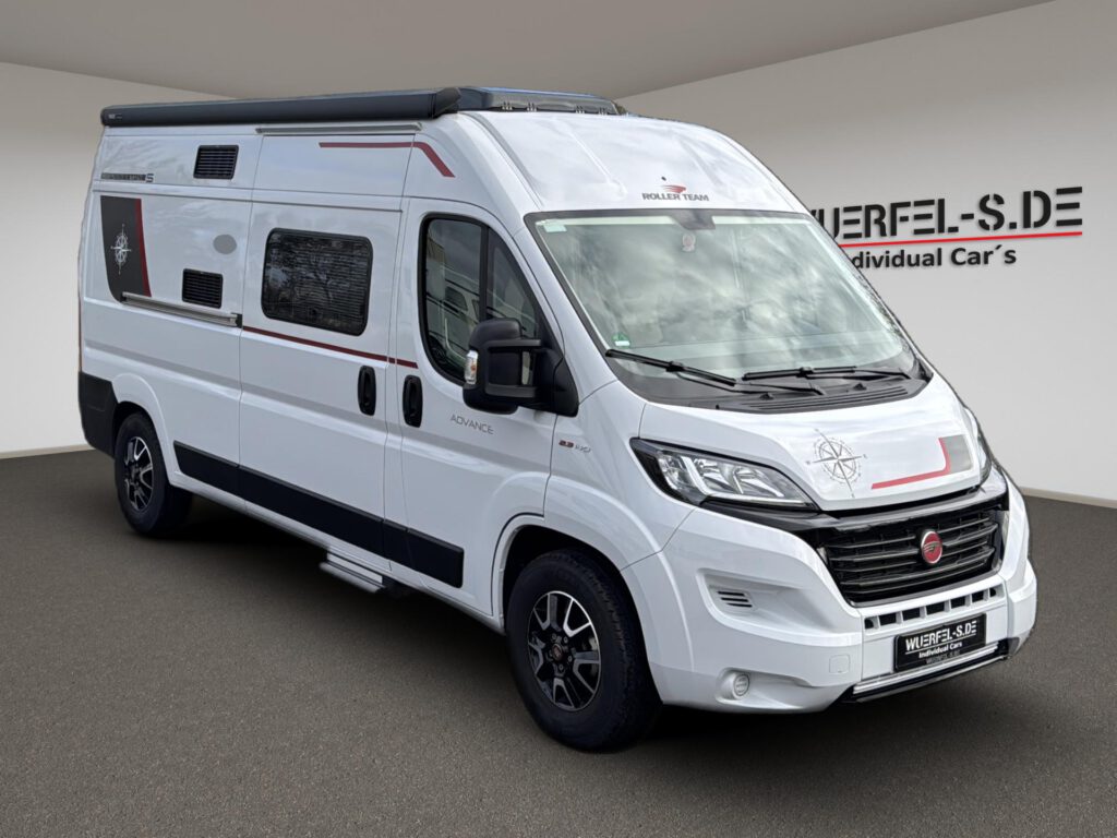Weißer Roller Team Campingkastenwagen mit Markise und Kompassdekoren, von schräg vorn.