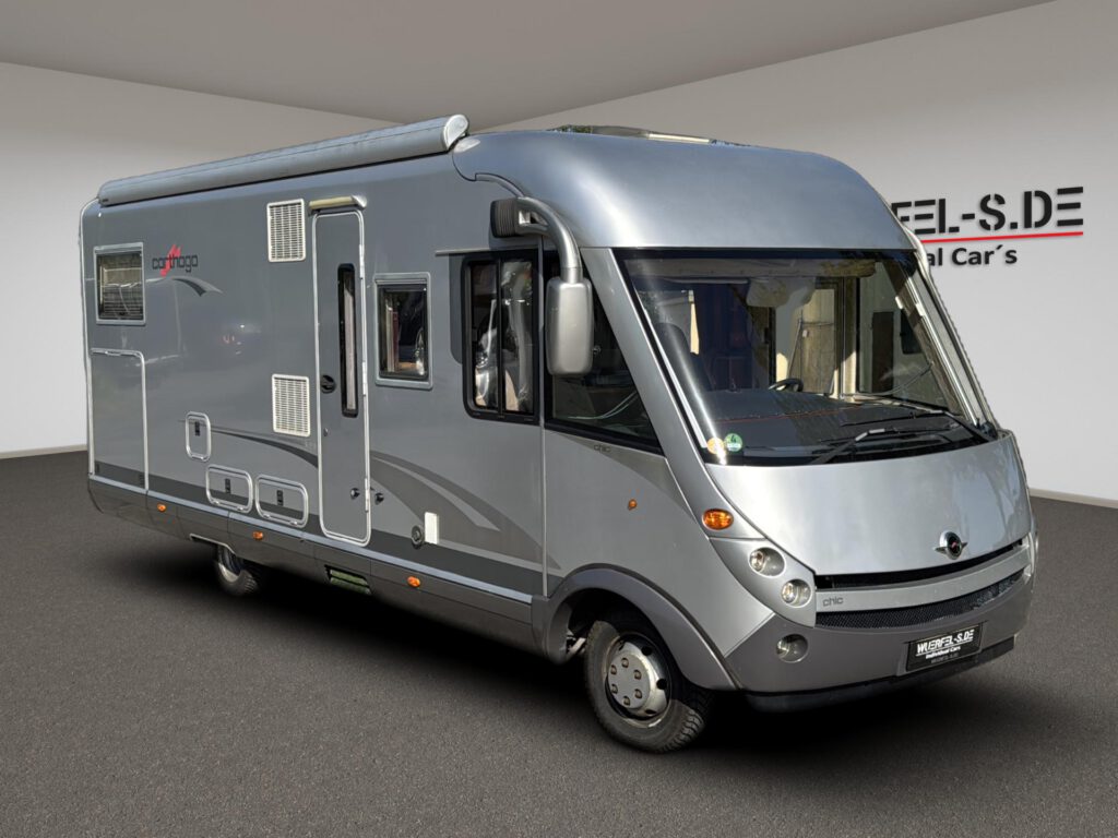 Silbernes vollintegriertes Carthago Chic Wohnmobil mit großer Frontscheibe und Markise, von schräg vorn.